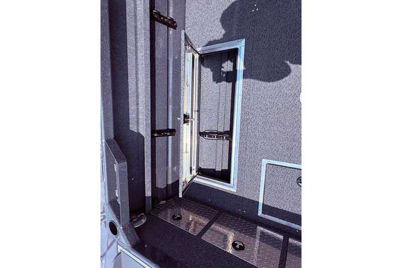 Slide: The Image of Interior view of 2026 Lund 210 Heavy Gauge boat with open storage compartment. - 35