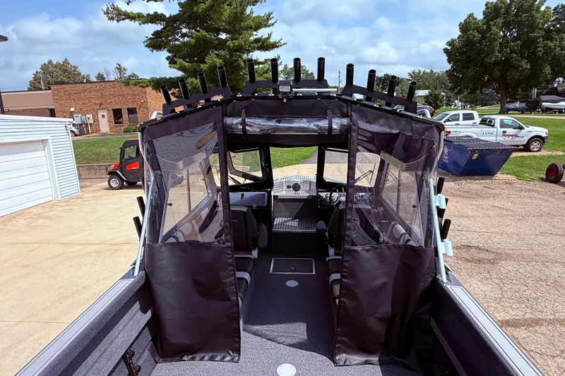 Slide: The Image of 2026 Lund 210 Heavy Gauge boat with enclosed cabin, parked outdoors on a sunny day. - 30