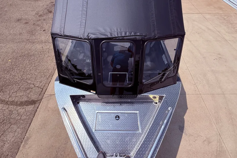 Slide: The Image of 2026 Lund 210 Heavy Gauge boat with black canopy and diamond plate deck. - 26
