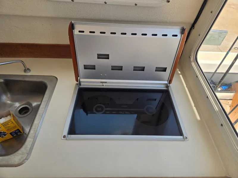 Slide: The Image of The galley of a 2002 C-Dory 22FT Cruiser features a stove next to a sink. - 15