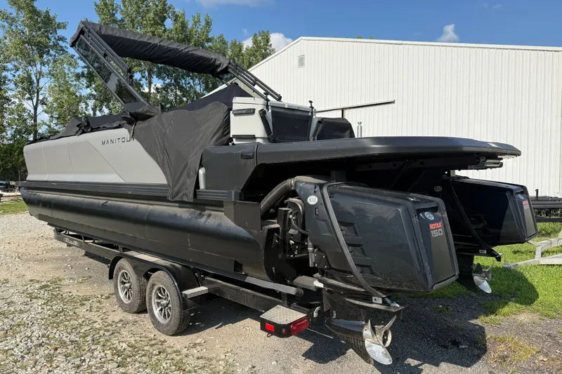 Slide: The Image of 2024 Manitou Explore Dual Engine boat on trailer, featuring dual Rotax 150 engines. - 2