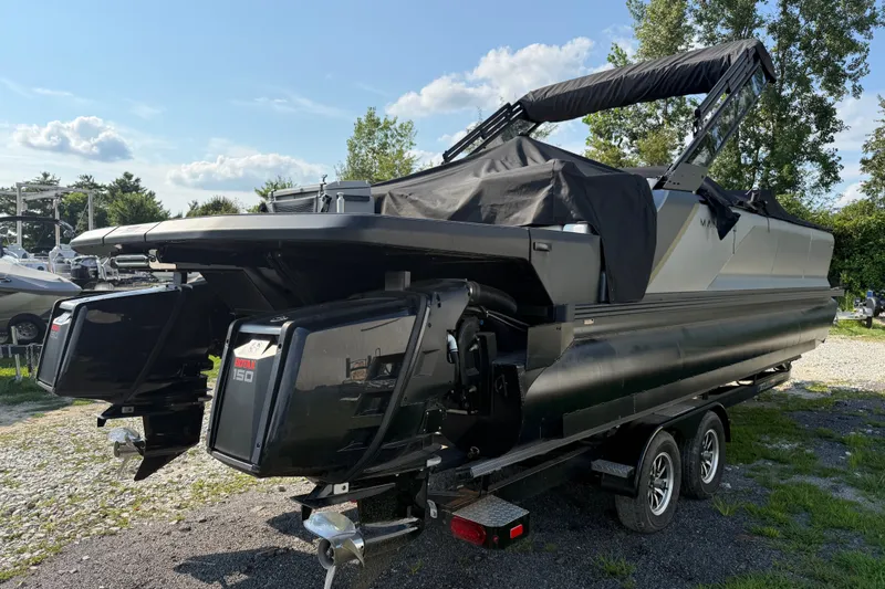 Slide: The Image of 2024 Manitou Explore Dual Engine boat on trailer, featuring dual outboard motors. - 4