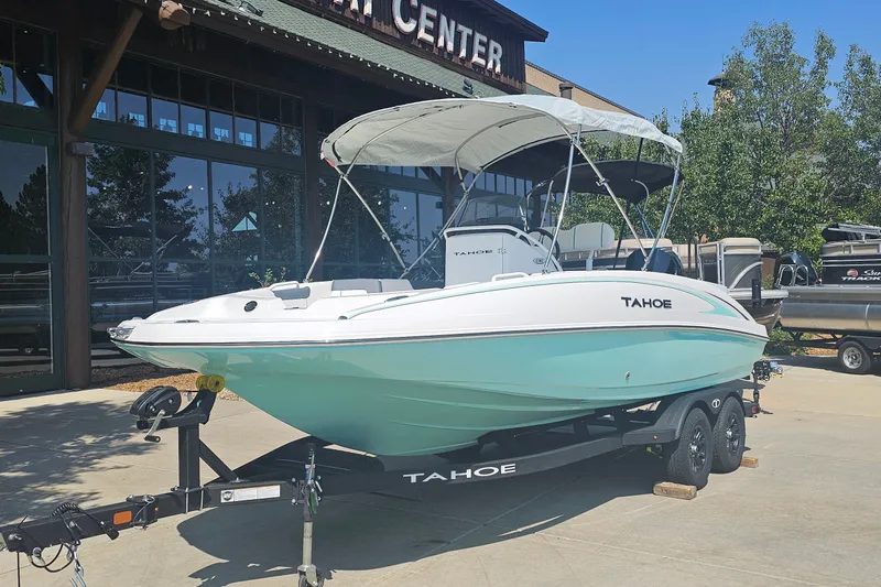 Slide: The Image of 2026 Tahoe 2150 CC boat on trailer, displayed outdoors near a showroom. - 2