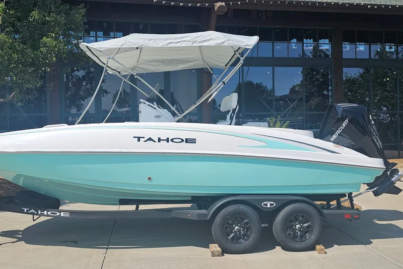 The Image of 2026 Tahoe 2150 CC boat with canopy on trailer, parked outdoors. - 0