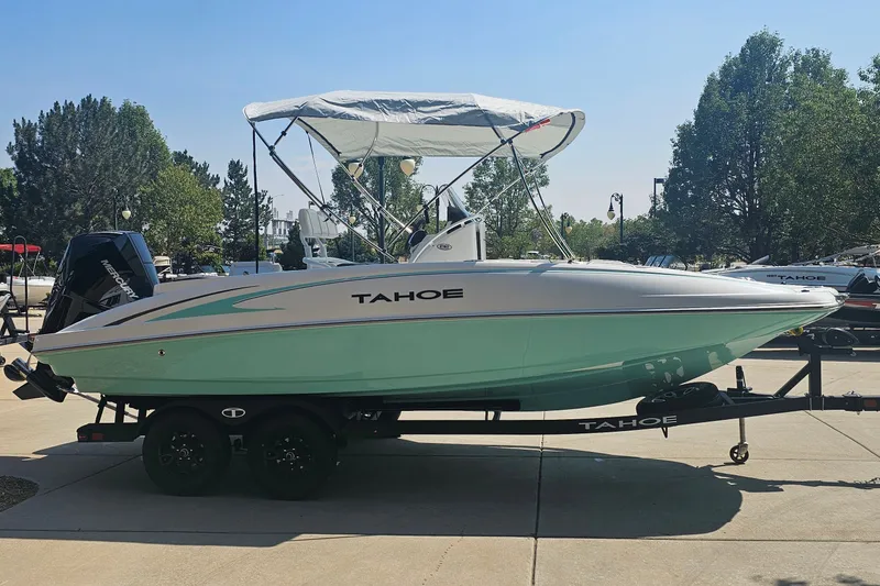 Slide: The Image of 2026 Tahoe 2150 CC boat on trailer, parked outdoors with trees in the background. - 1
