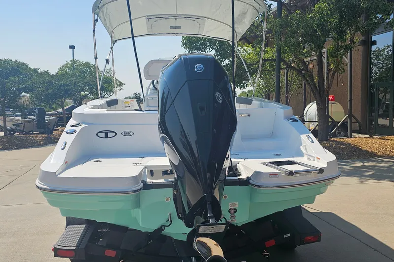 Slide: The Image of 2026 Tahoe 2150 CC boat with outboard motor, parked outdoors. - 3