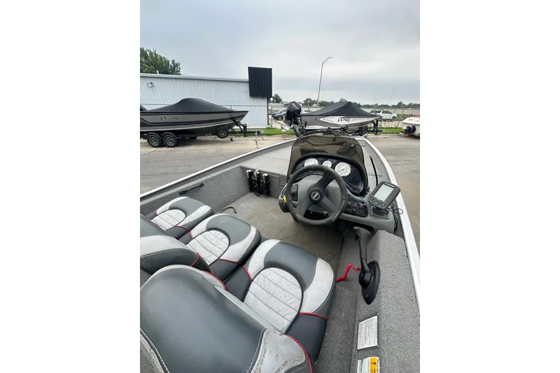 Slide: The Image of 2006 Bass Tracker Pro 17 boat interior with steering wheel and seating, parked outdoors. - 17
