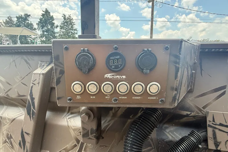 Slide: The Image of Control panel of 2024 Pro-Drive 1854 SBX TD boat with voltage display and switches. - 9