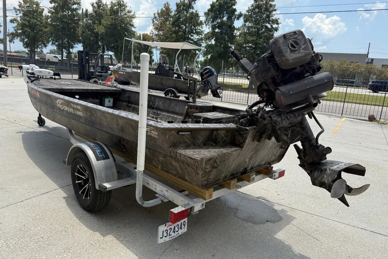 Slide: The Image of 2024 Pro-Drive 1854 SBX TD boat on trailer, featuring camouflage design and outboard motor. - 4
