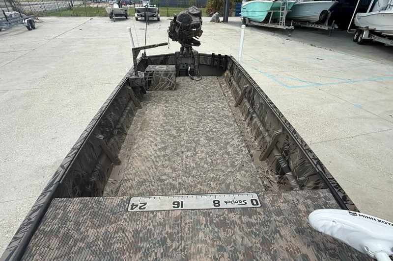 Slide: The Image of 2024 Pro-Drive 1854 SBX TD boat with camouflage interior and outboard motor. - 7
