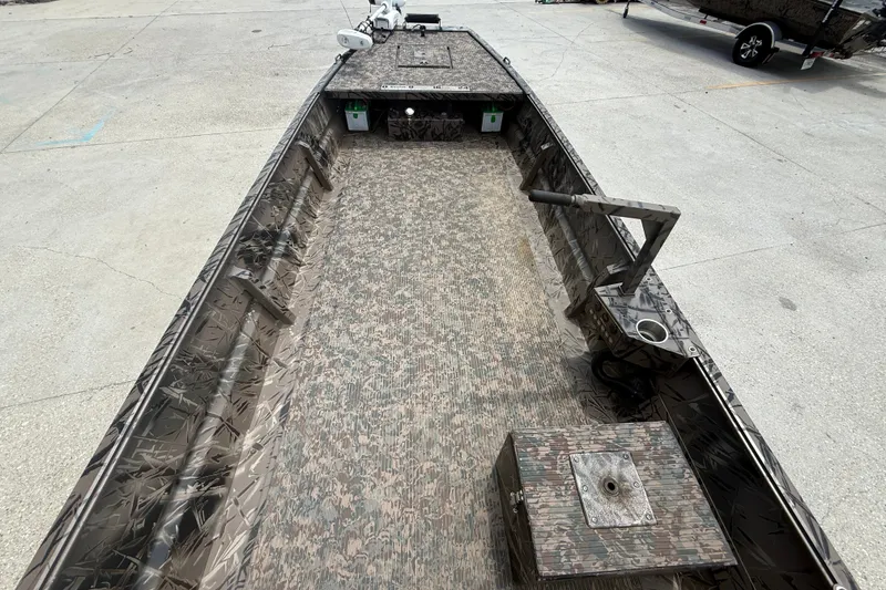 Slide: The Image of 2024 Pro-Drive 1854 SBX TD boat with camouflage interior, docked on concrete surface. - 5