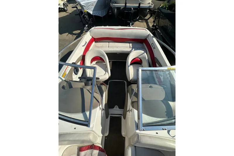 Slide: The Image of 2004 Larson SEi 190 boat interior with red and white seating, open windshield. - 14