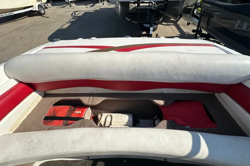 Slide: The Image of 2004 Larson SEi 190 boat interior with red and white seating and storage area. - 13