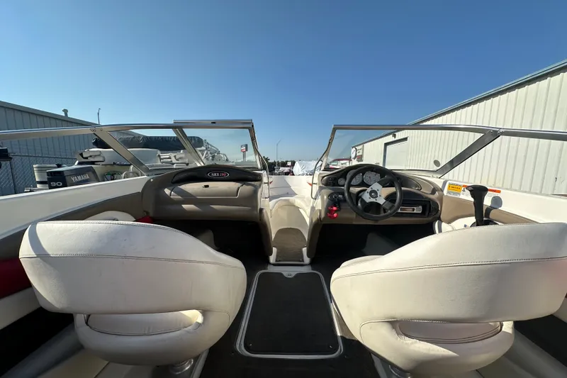 Slide: The Image of Interior view of a 2004 Larson SEi 190 boat with steering wheel and seating. - 12