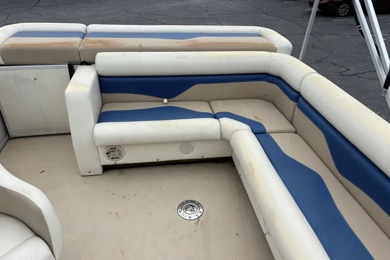 Slide: The Image of 2015 Godfrey Sweetwater boat interior with beige and blue cushioned seating. - 16