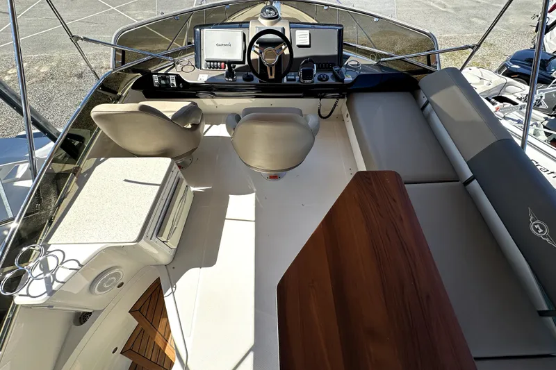 Slide: The Image of 2014 Marquis 420 Sport Bridge cockpit with helm, seating, and navigation equipment. - 14