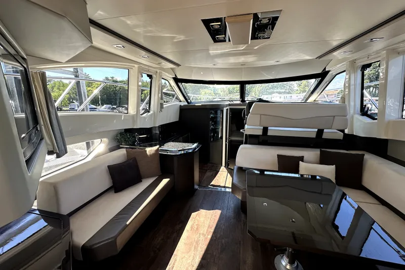 Slide: The Image of Luxurious interior of a 2014 Marquis 420 Sport Bridge yacht with elegant seating and panoramic windows. - 24