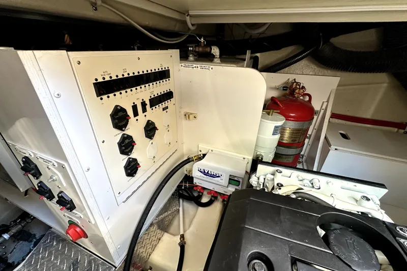 Slide: The Image of Engine room of 2014 Marquis 420 Sport Bridge with control panels and fire extinguisher. - 44