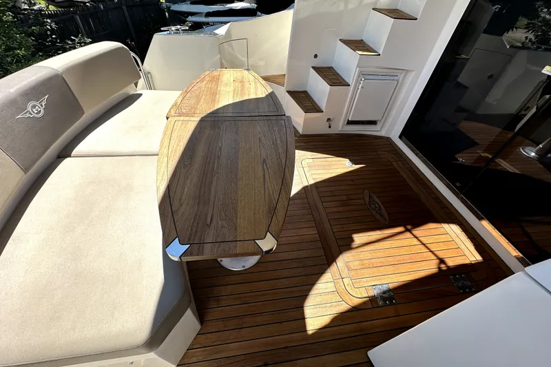 Slide: The Image of 2014 Marquis 420 Sport Bridge yacht interior with wooden deck and seating area. - 13