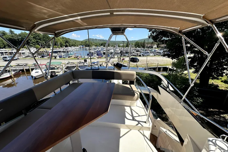 Slide: The Image of Flybridge view of 2014 Marquis 420 Sport Bridge yacht docked at a marina. - 12