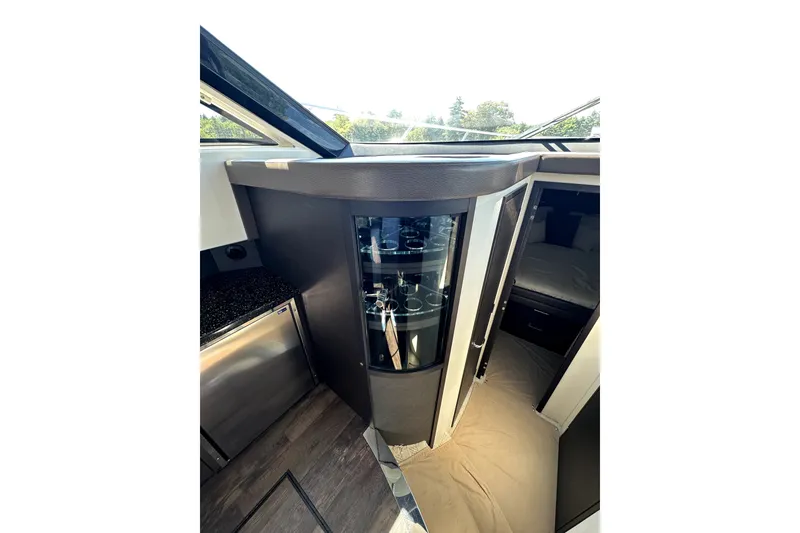 Slide: The Image of Interior of 2014 Marquis 420 Sport Bridge yacht, featuring modern cabinetry and a cozy sleeping area. - 30