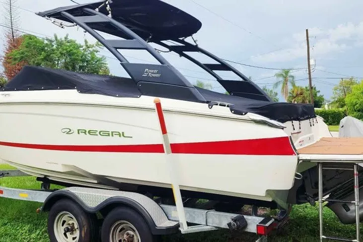 Slide: The Image of 2022 Regal LS2 boat on trailer, featuring sleek design and Power Tower, parked outdoors. - 4