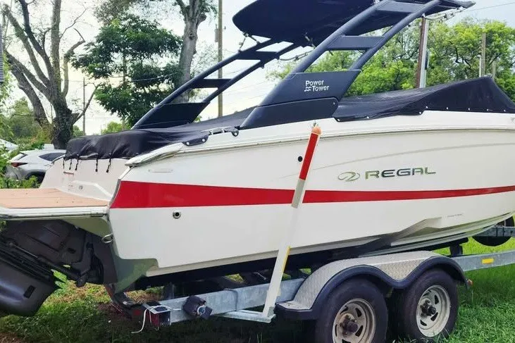 Slide: The Image of 2022 Regal LS2 boat on trailer, featuring sleek design and Power Tower, parked outdoors. - 6