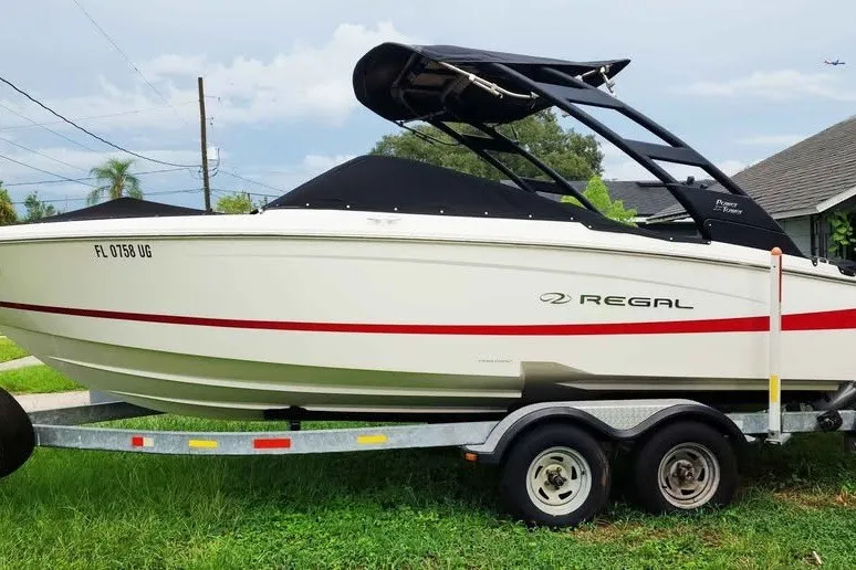 Slide: The Image of 2022 Regal LS2 boat on trailer, featuring sleek design and black canopy. - 2