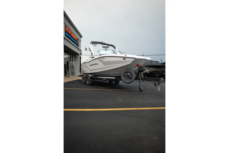 Slide: The Image of 2027 MasterCraft NXT20 boat on trailer outside dealership. - 13