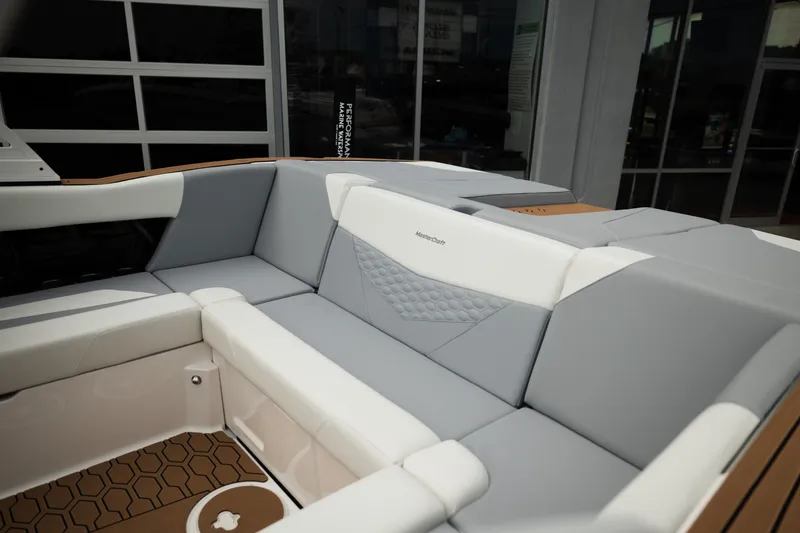 Slide: The Image of 2027 MasterCraft NXT20 boat interior with gray and white cushioned seating. - 20
