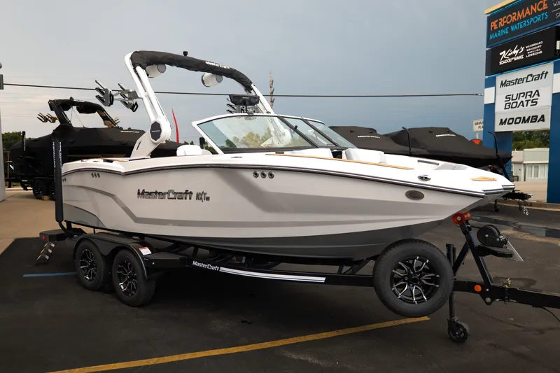 Slide: The Image of 2027 MasterCraft NXT20 boat on trailer at dealership, showcasing sleek design and modern features. - 12