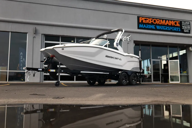 The Image of 2027 MasterCraft NXT20 boat on trailer outside Performance Marine Watersports store. - 1