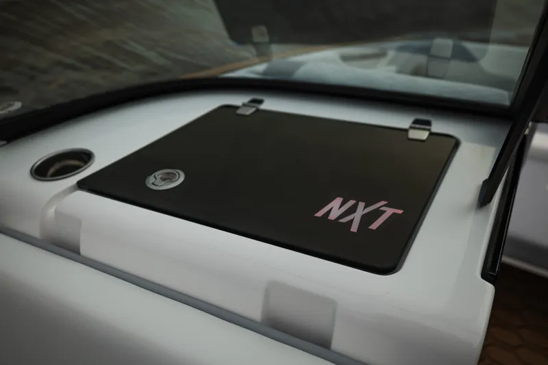 Slide: The Image of 2027 MasterCraft NXT20 boat dashboard with NXT logo and storage compartment. - 34
