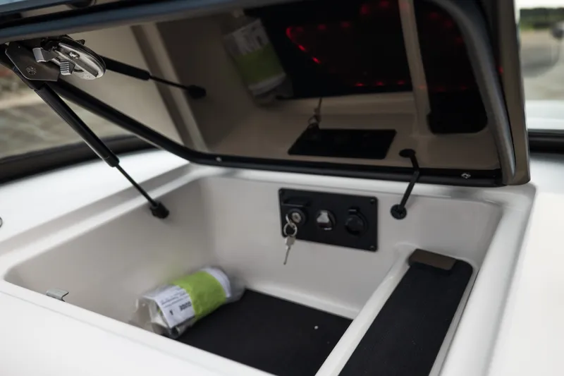 Slide: The Image of Open storage compartment in 2027 MasterCraft NXT20 boat, featuring keys and manual. - 35