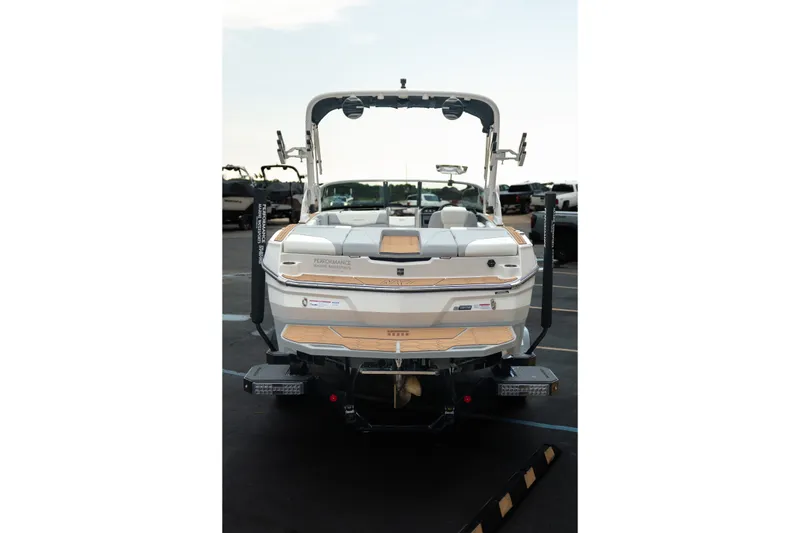 Slide: The Image of 2027 MasterCraft NXT20 boat, rear view, parked in a marina, showcasing sleek design. - 8