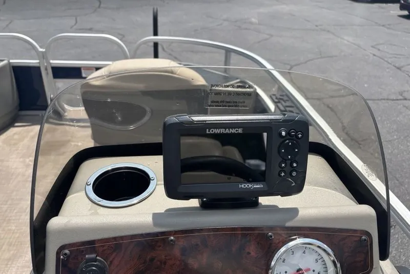 Slide: The Image of 2024 Sun Tracker Bass Buggy 18 DLX dashboard with Lowrance fish finder and cup holder. - 19
