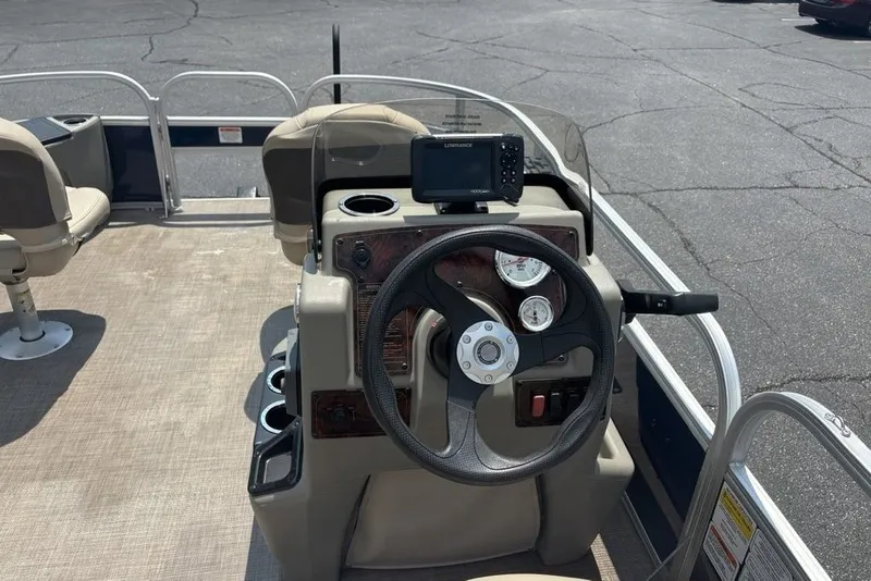 Slide: The Image of 2024 Sun Tracker Bass Buggy 18 DLX pontoon boat dashboard with steering wheel and gauges. - 18