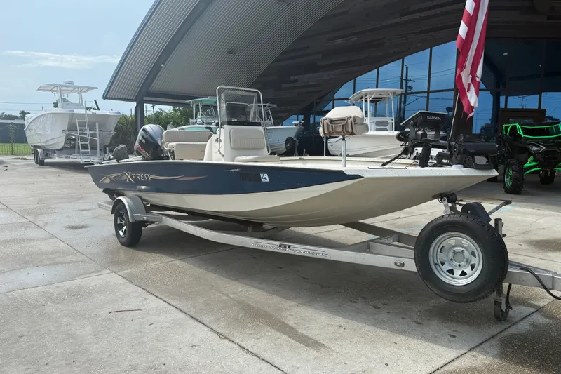 Slide: The Image of 2018 Express 20 boat on trailer, parked outside a modern building. - 3
