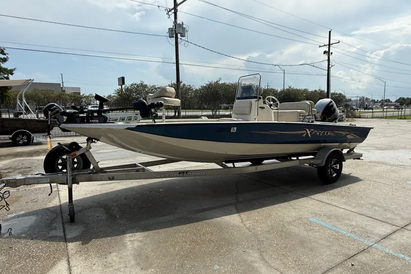 Slide: The Image of 2018 Express 20 boat on trailer, parked outdoors under cloudy sky. - 9