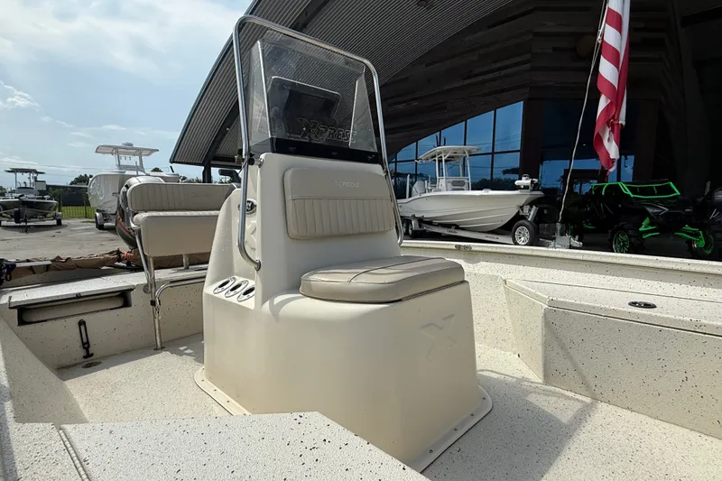 Slide: The Image of 2018 Express 20 boat interior with seating and console, displayed outdoors near other boats. - 13