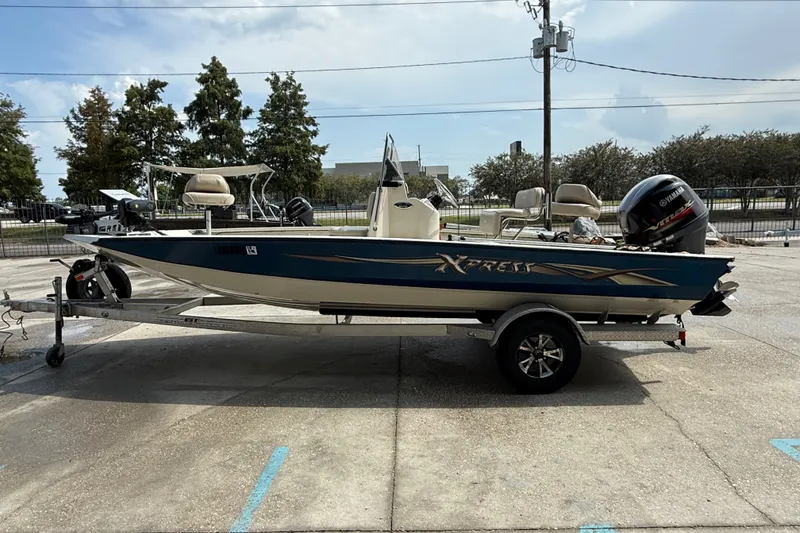 Slide: The Image of 2018 Express 20 boat on trailer, parked outdoors, featuring Yamaha outboard motor. - 8