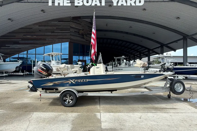 Slide: The Image of 2018 Express 20 boat on trailer at The Boat Yard, featuring Yamaha engine. - 2