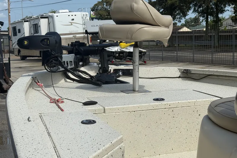 Slide: The Image of 2018 Express 20 boat deck with seating and motor, parked near RVs. - 18