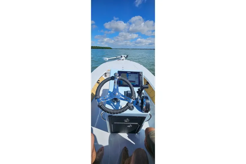 Slide: The Image of 2022 East Cape Vantage VHP boat dashboard with steering wheel on open water. - 25