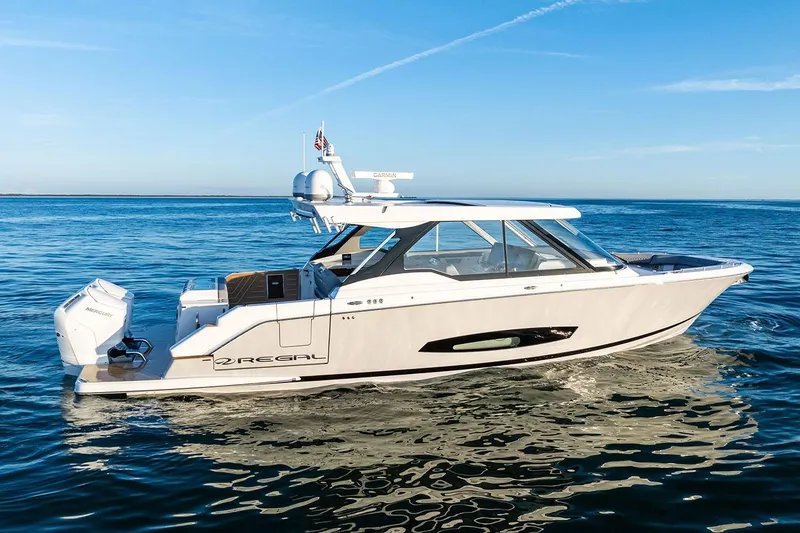 Slide: The Image of Manufacturer Provided Image: 2026 Regal LX43 boat cruising on calm blue waters under clear skies. - 2