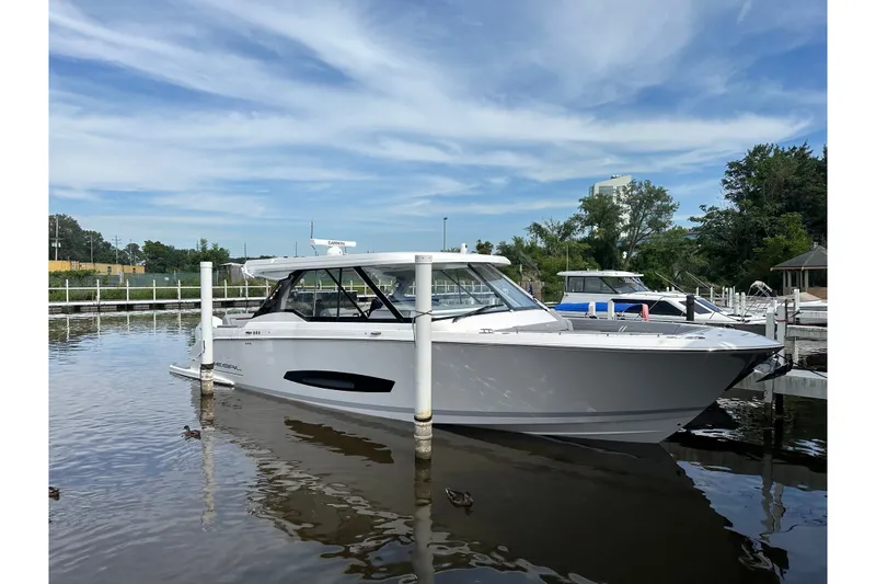 The Image of 2027 Regal LX43 boat docked on calm water under a clear sky. - 0