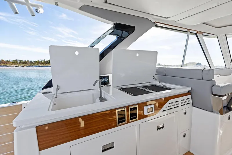 Slide: The Image of Manufacturer Provided Image: Luxurious 2026 Regal LX43 yacht kitchen with sink and grill, overlooking serene waters. - 12