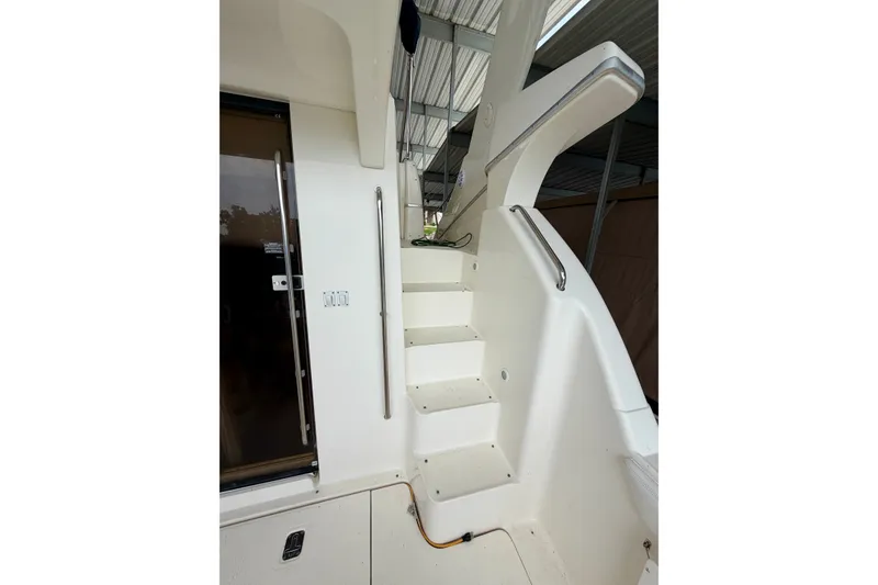 Slide: The Image of Staircase on a 2002 Silverton 330 Sport Bridge yacht, featuring sleek white design. - 10