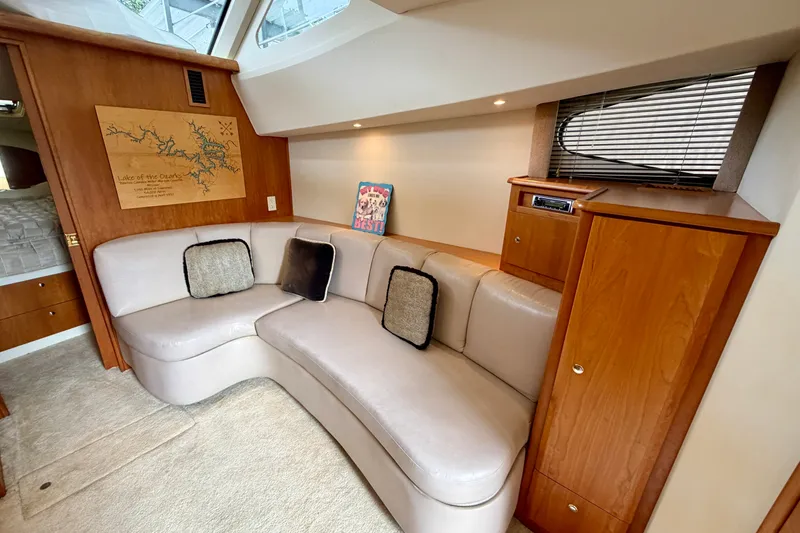 Slide: The Image of Interior of 2002 Silverton 330 Sport Bridge with cozy seating and wooden cabinetry. - 24