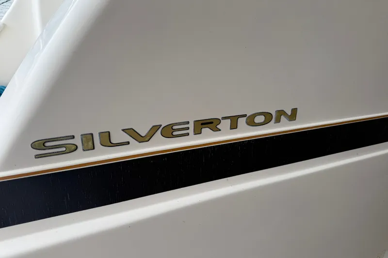 Slide: The Image of Close-up of 2002 Silverton 330 Sport Bridge logo on white boat surface. - 40